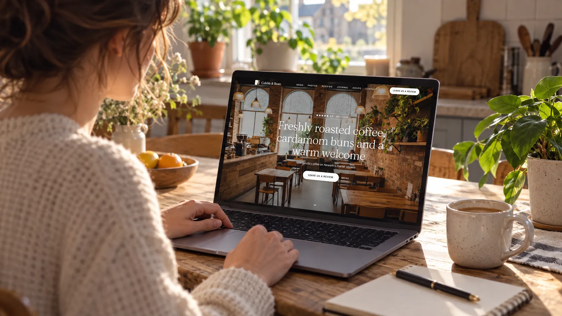 A laptop on a kitchen table showing a café's website