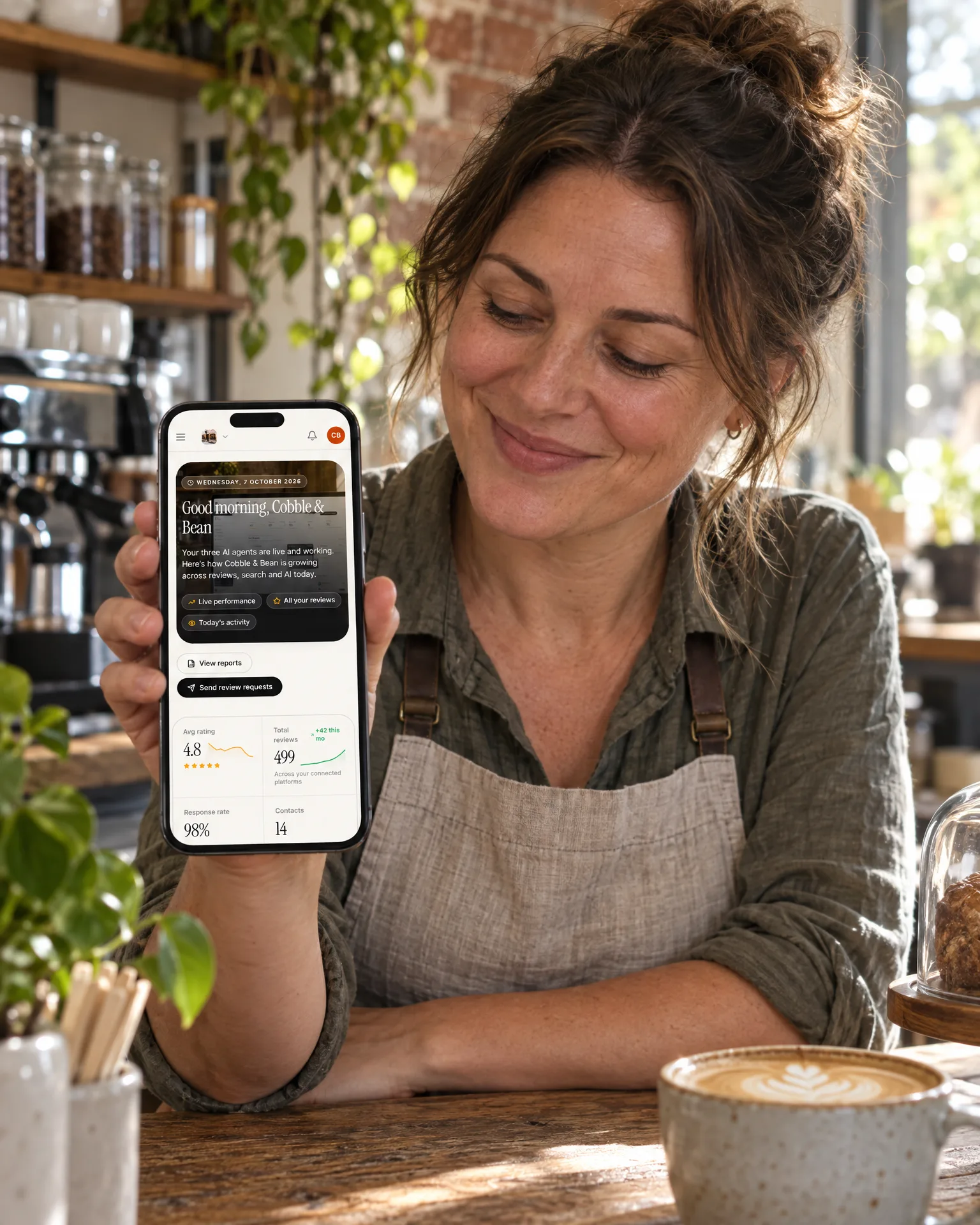 A café owner smiling at her LocalQuiver dashboard on her phone